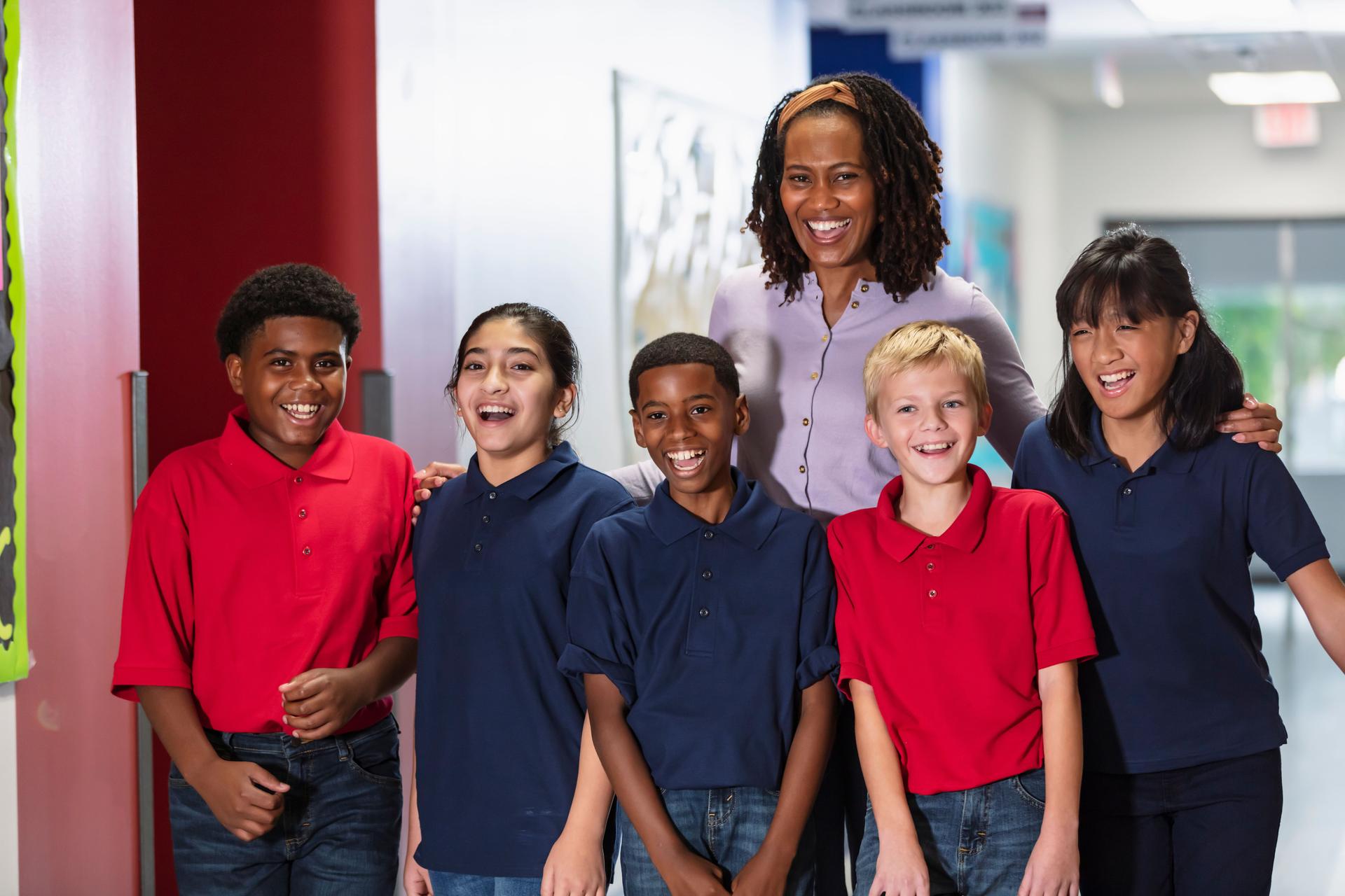 Teacher with middle school students in hallway